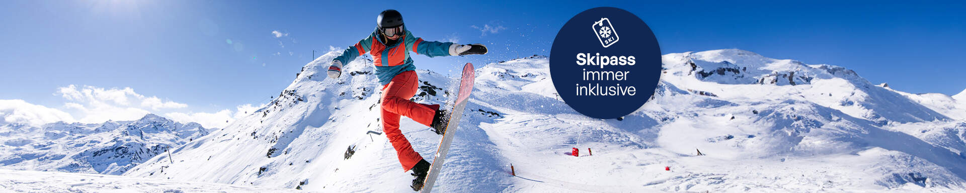 Person, die eine Snowboardfigur macht, mit schneebedeckten Gipfeln im Hintergrund