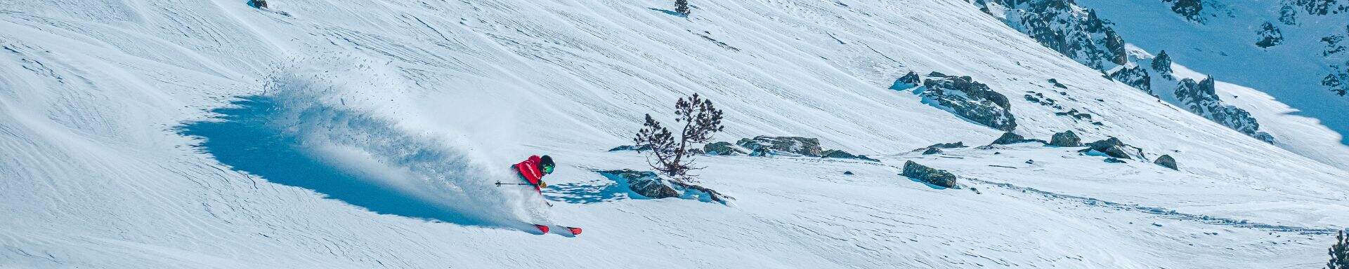 Ein Skifahrer fährt in Andorra die Skipiste hinunter